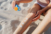 Close-up of applying sunscreen on legs at the beach for skin protection